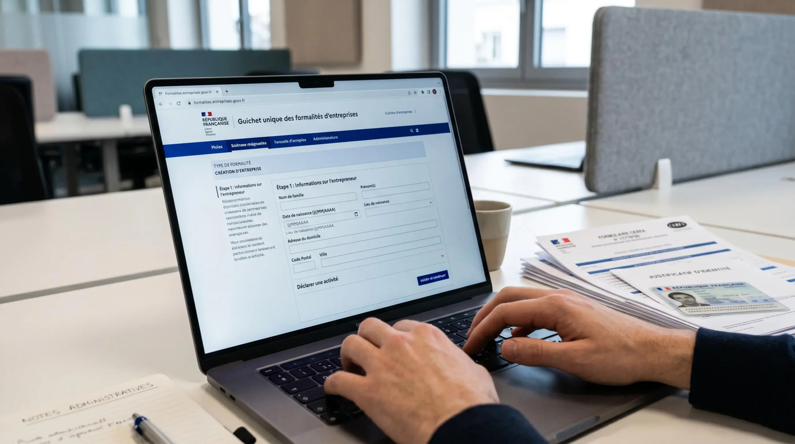 Mains tapant sur clavier d'ordinateur portable affichant le portail officiel français des formalités d'entreprises avec formulaires de déclaration
